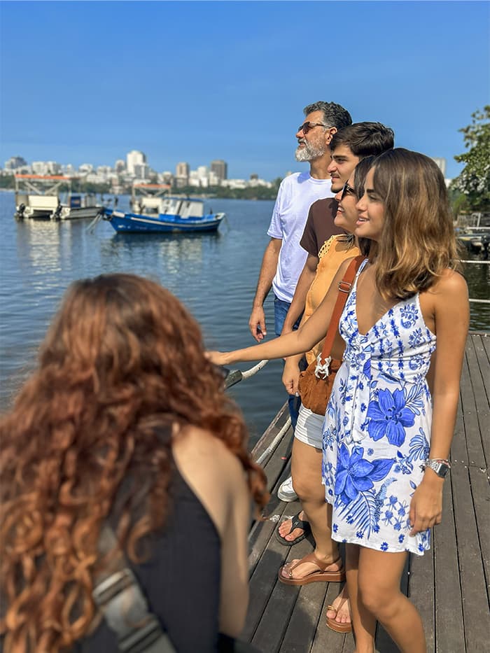 família durante ensaio fotográfico na orla da Baía de Guanabara com a cidade do Rio de Janeiro ao fundo